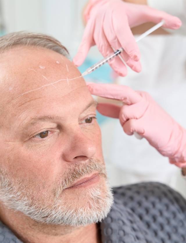 Gray-haired,Man,With,A,Beard,Receives,Injections,In,The,Forehead Gray-haired,Man,With,A,Beard,Receives,Injections,In,The,Forehead